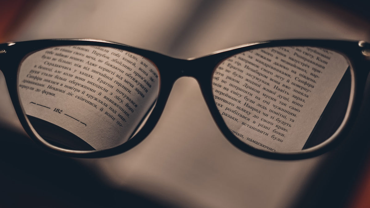 Reflection of text across the lenses of black eyeglasses