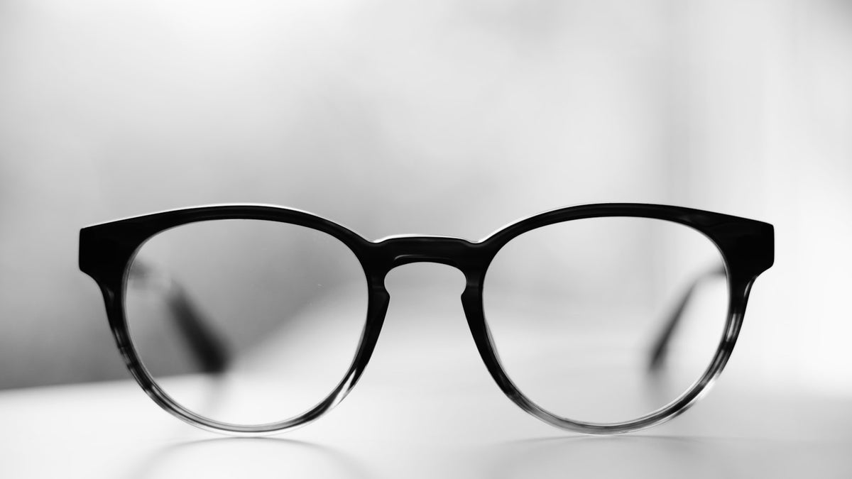 Pair of glasses folded on a wooden surface