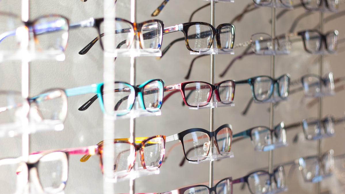 Assorted-color eyeglasses arranged on a display rack