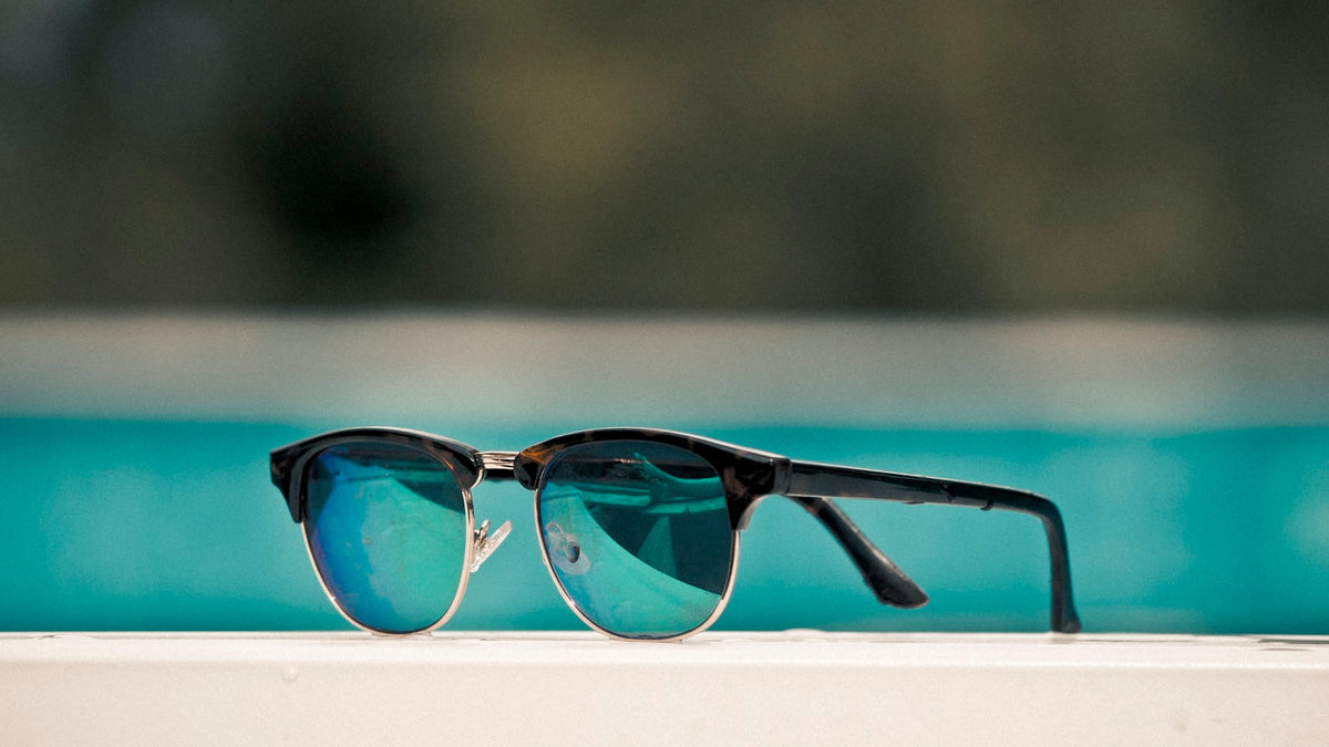 Black-framed browline clubmaster sunglasses on a surface