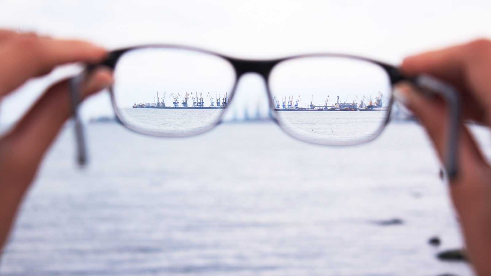 A pair of eyeglasses held up to the light — how to adjust acetate frames at home