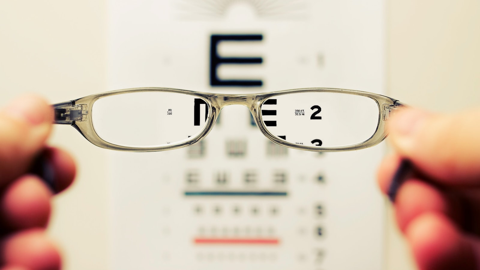 Clear eyeglasses held up showing the nose bridge and pads — why glasses leave marks on your nose