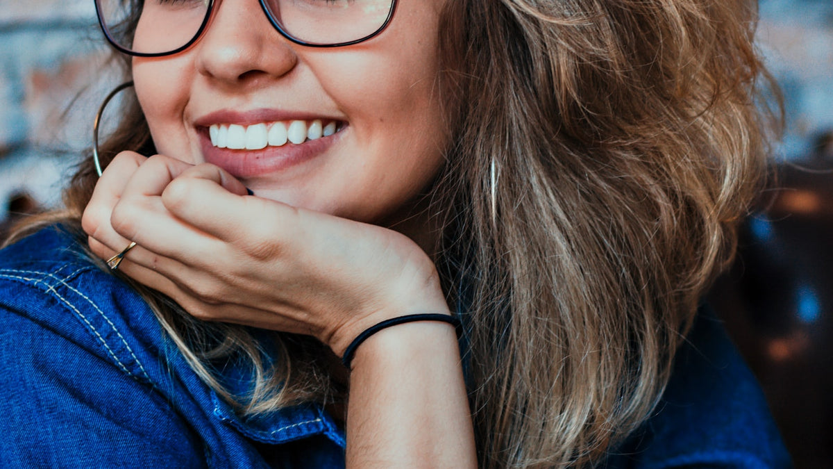 Close-up of a woman wearing slim black-framed eyeglasses