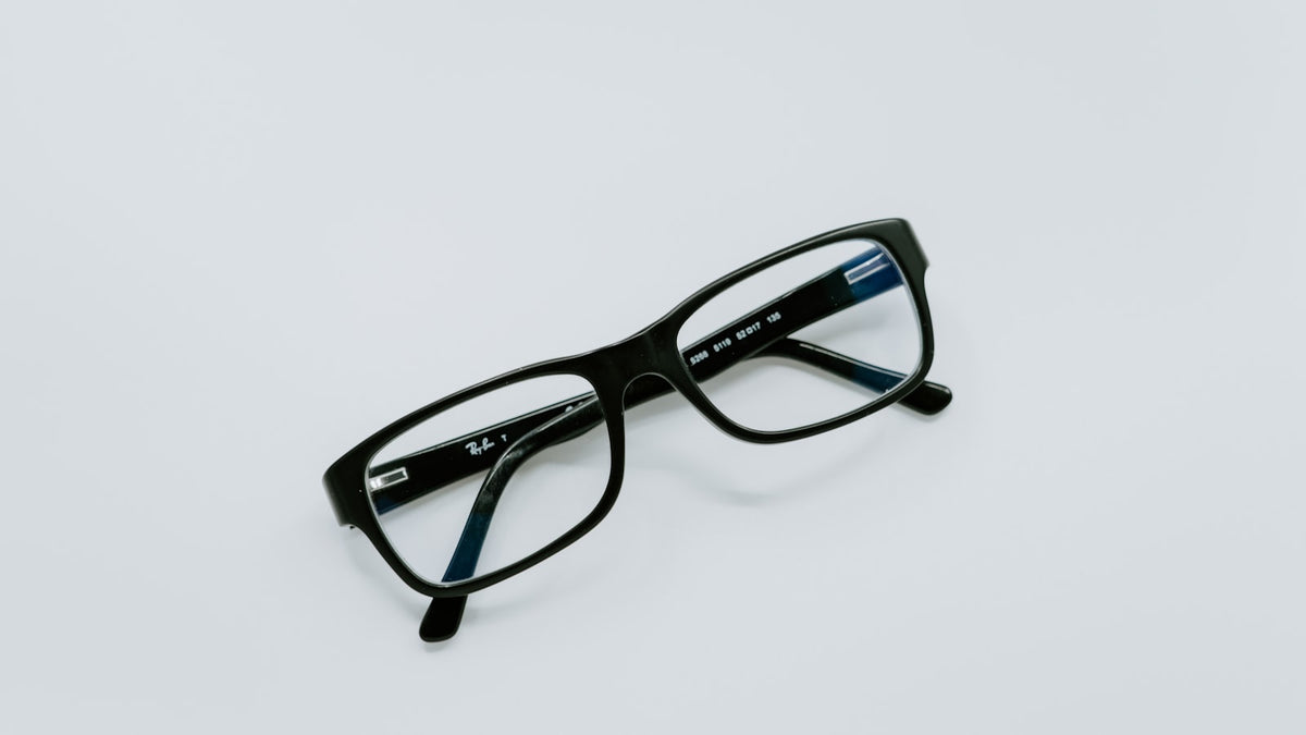 Black-framed eyeglasses on a neutral surface