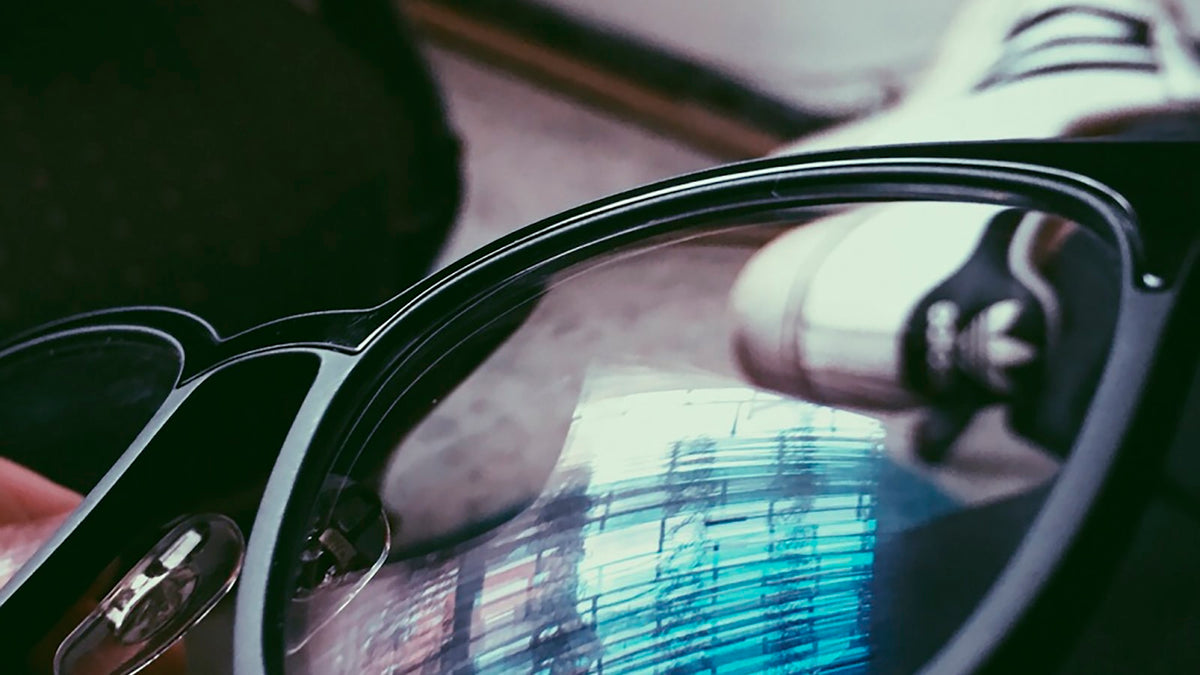 Grey metal eyeglasses folded, close view of the hinge and temple