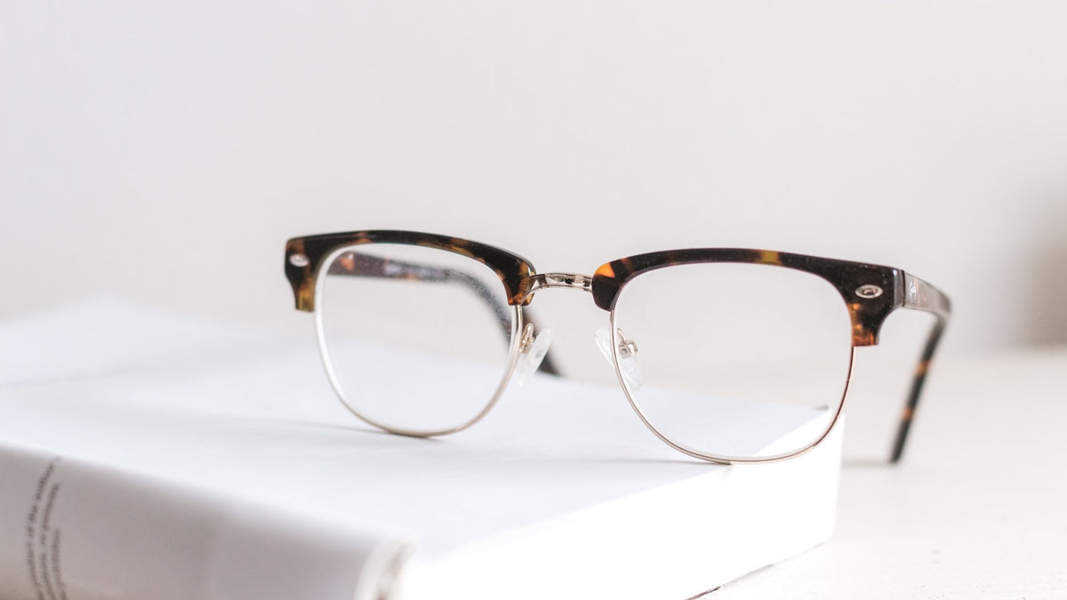 Clear anti-reflective eyeglasses resting on an open book