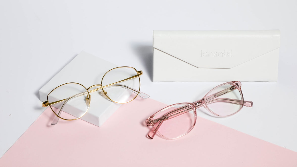 Gold metal-framed glasses with nose pads on white paper