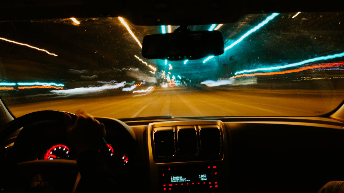 Person driving a car at night with oncoming headlights