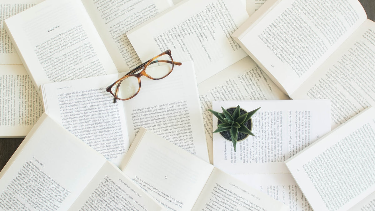 Tortoiseshell reading glasses resting on open books