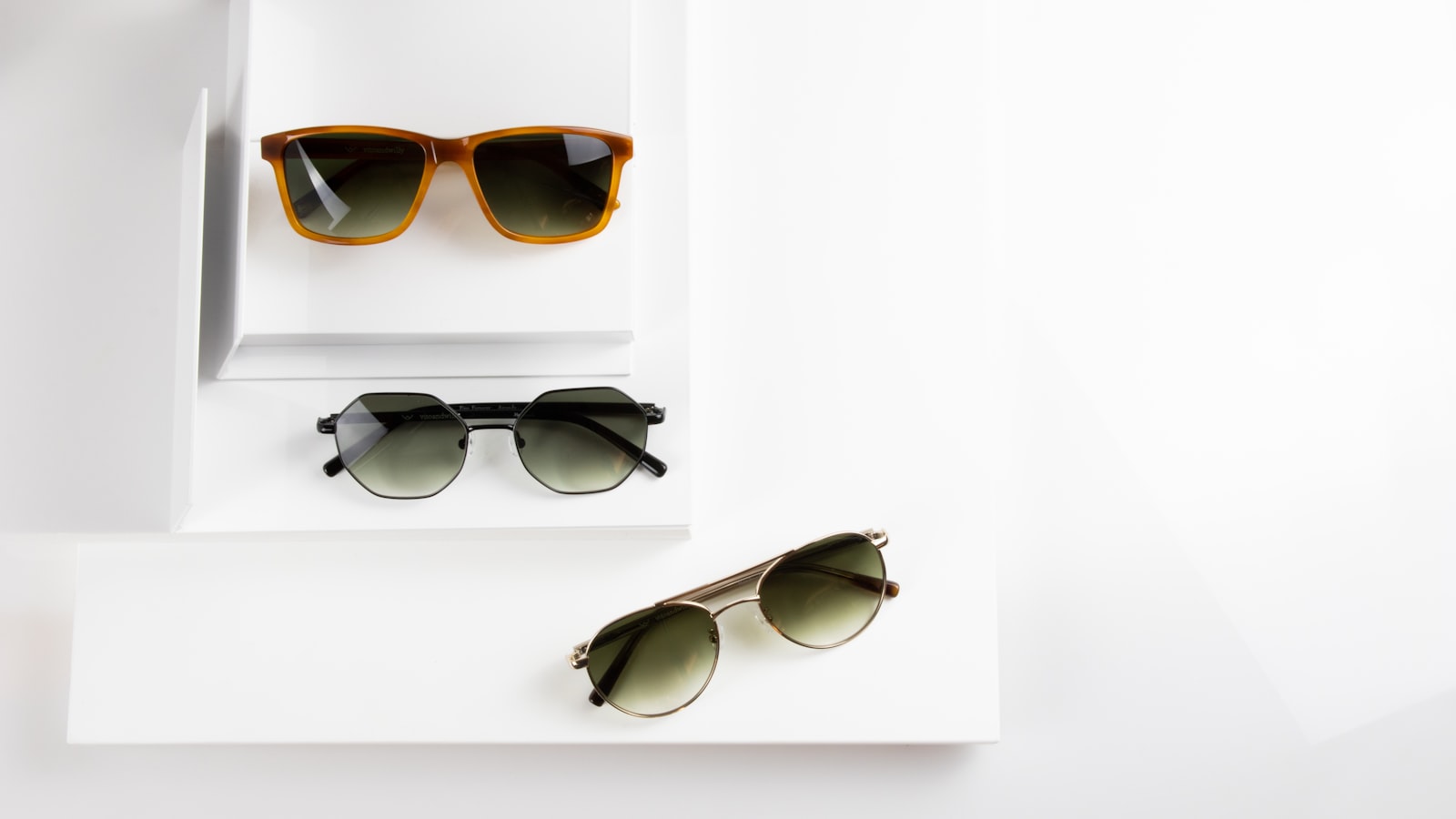 Three pairs of glasses arranged on white pedestals — the complete eyewear care manual