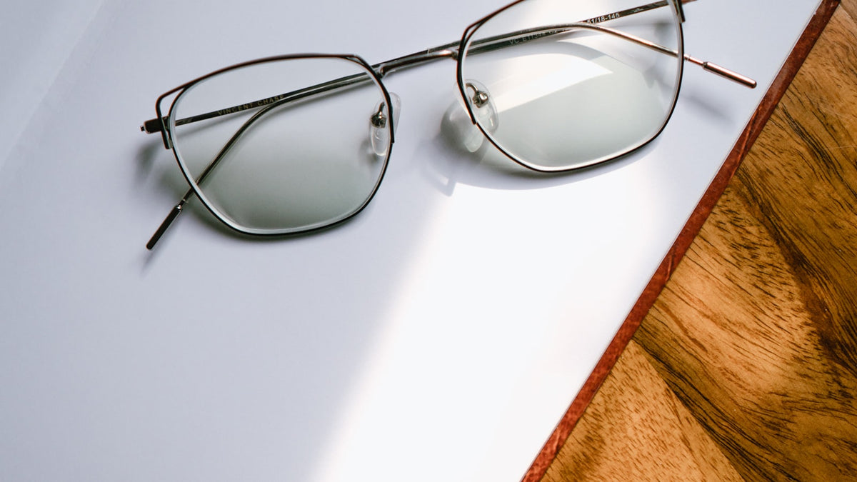 Black-framed eyeglasses resting on a white table