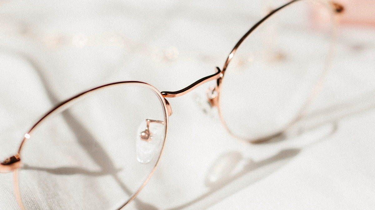 Silver metal-framed eyeglasses on white textile