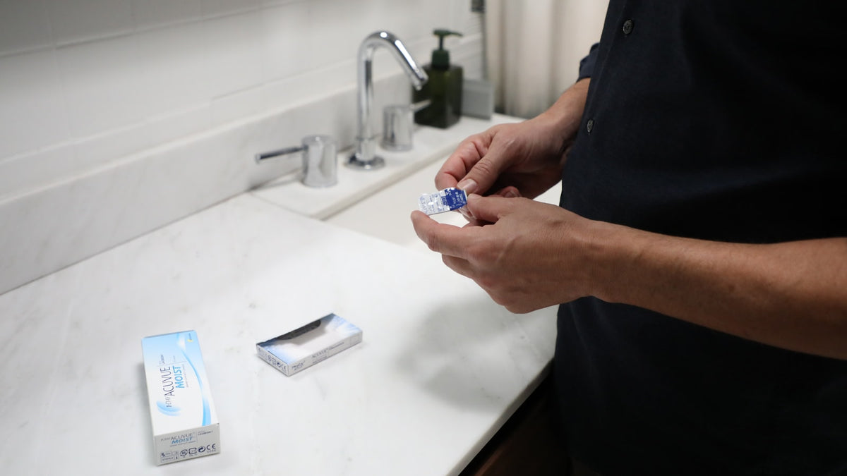 Person holding a contact lens blister pack
