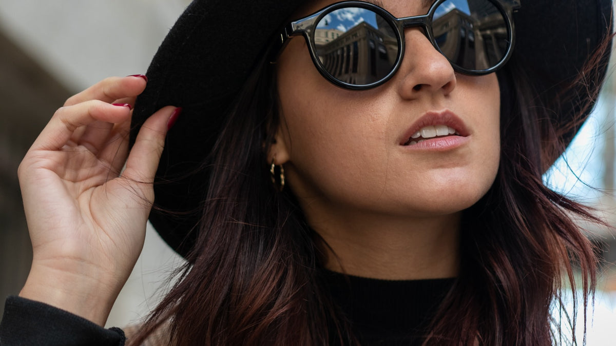 Woman wearing a black hat and oversized sunglasses