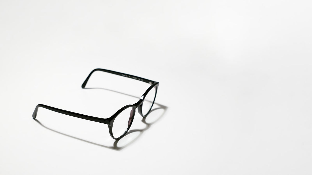 Black-framed prescription eyeglasses on a white surface