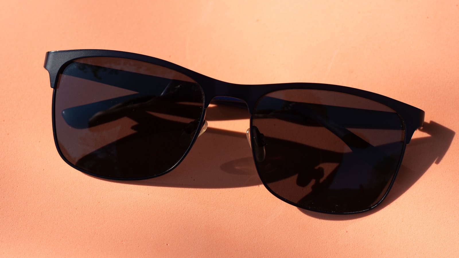 Person holding sunglasses toward the light — why phone screens go dark with polarized lenses