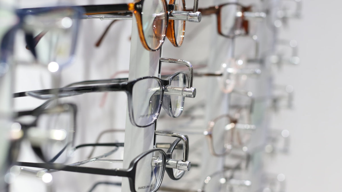 Thin silver-framed eyeglasses resting on clear glass