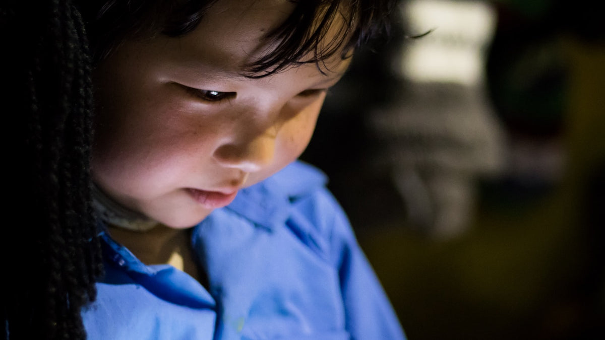 Young child looking closely at a tablet screen