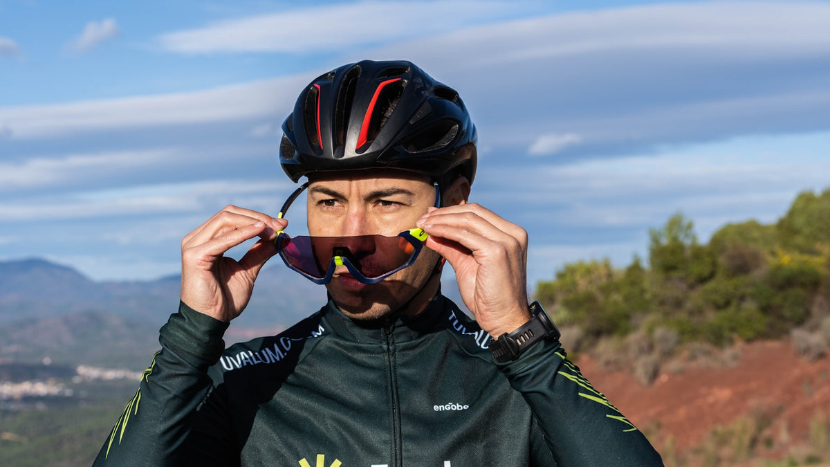 Cyclist in a helmet holding a pair of sport sunglasses