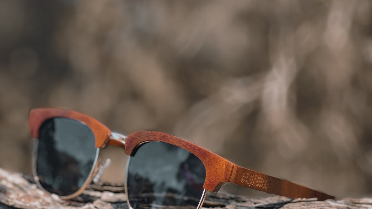 Sunglasses resting on a piece of natural wood