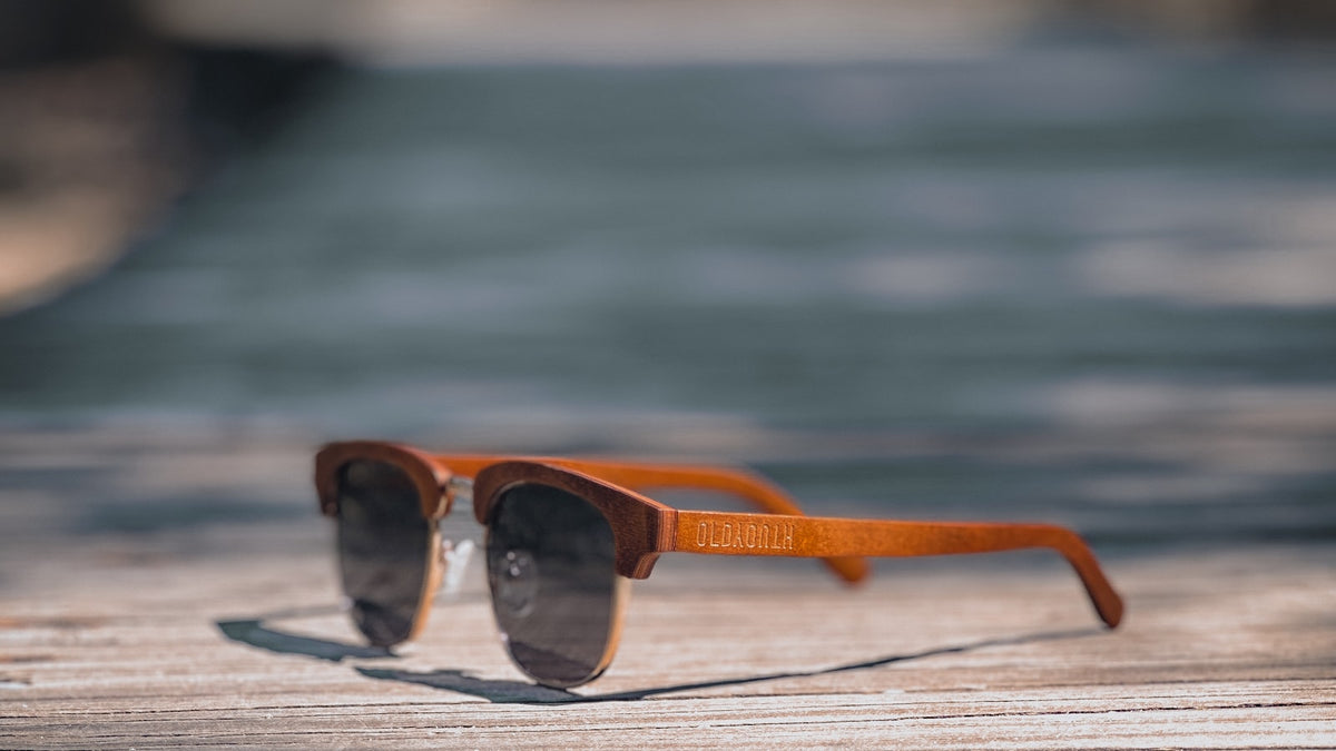 Sunglasses resting on a wooden table surface