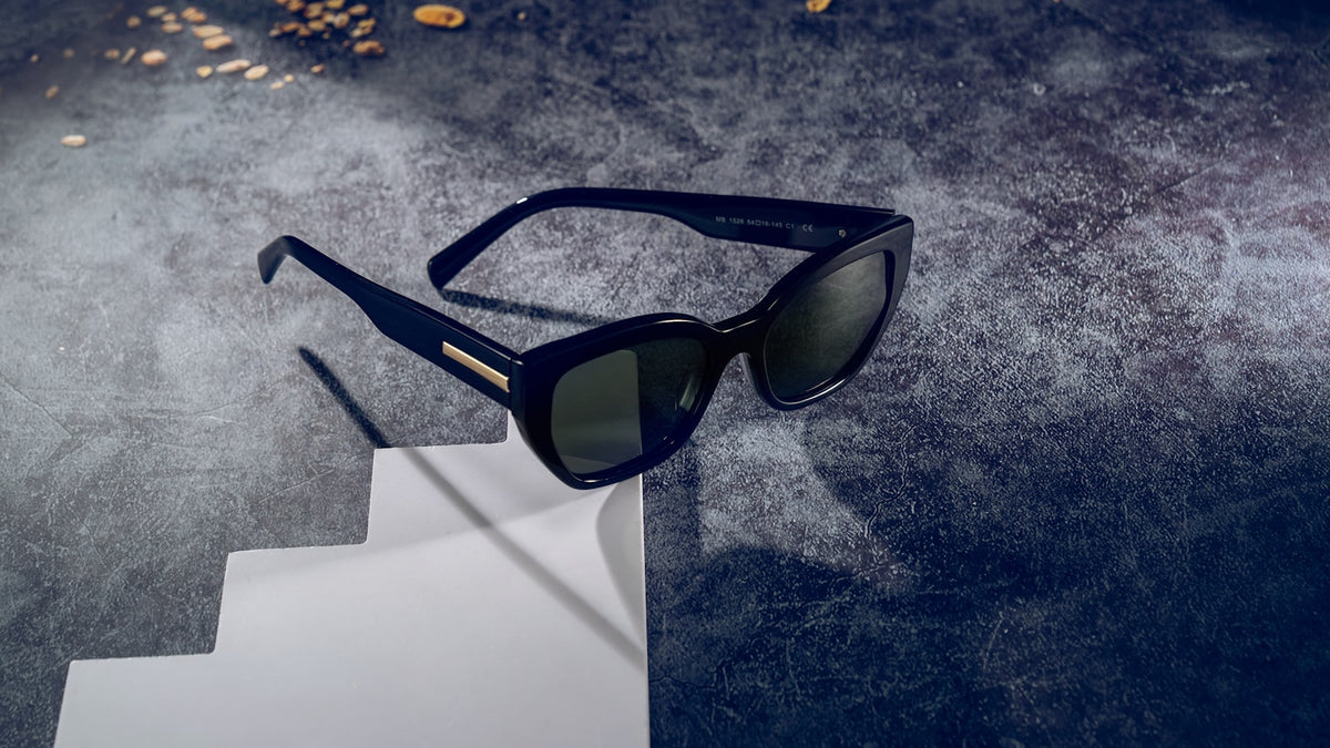 Black cat-eye sunglasses on a textured stone surface