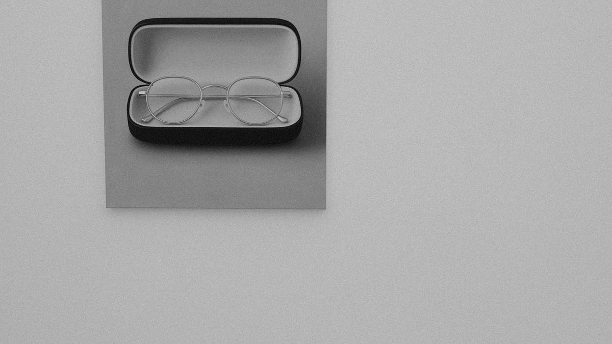 Glasses and a case packed beside travel essentials