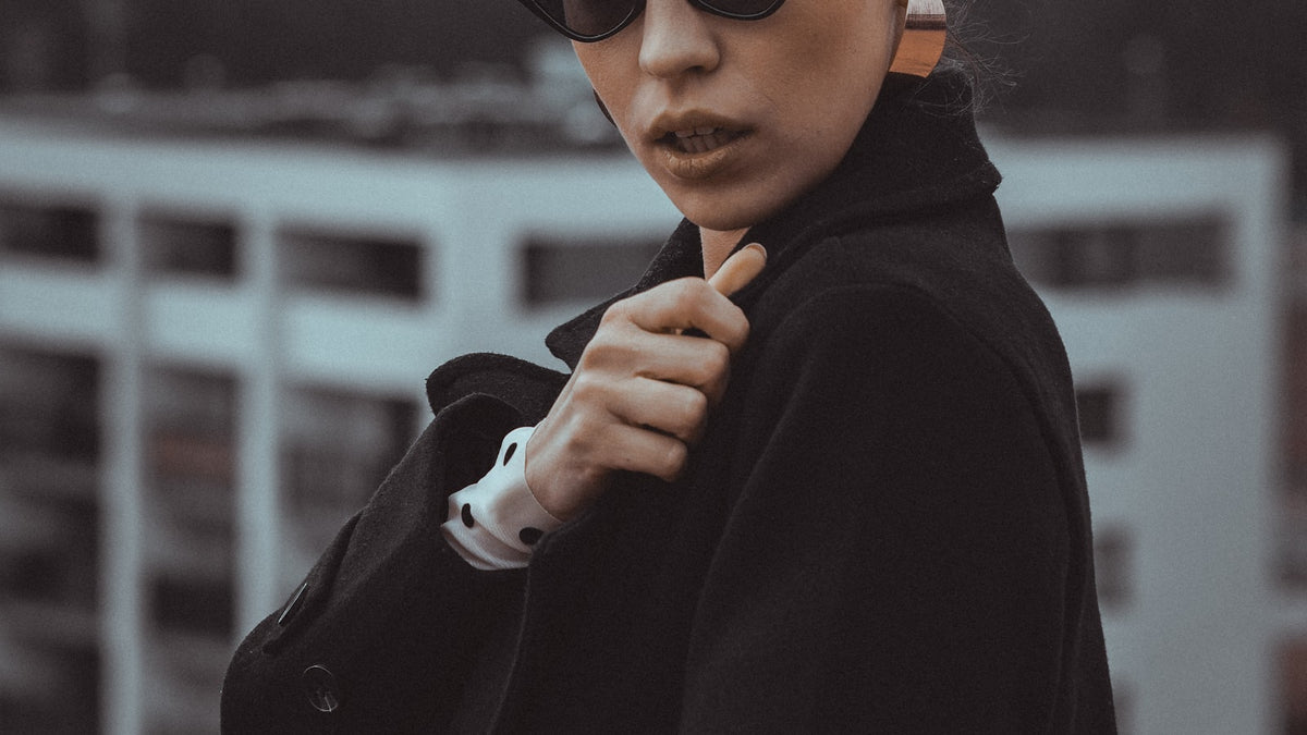 Woman wearing sunglasses and a coat outdoors